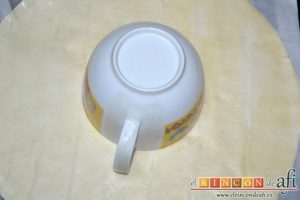 Roscón de hojaldre para Reyes, desplegar las láminas de hojaldre, pegarlas con agua de azahar y poner una taza en el centro