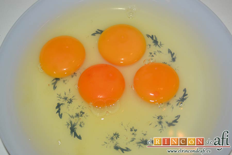 Revuelto de calabacines con setas, cascar los cuatro huevos en un plato