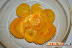 Pudin con brioche y melocotón en almíbar, cortar las rodajas de melocotón y ponerlas en el molde sobre el caramelo