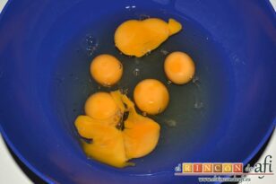 Tortilla de papas con cebolla, pimiento asado y chorizo, cascar los huevos en un bol