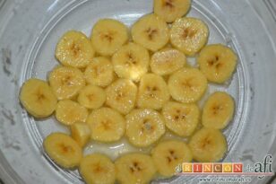 Fruta caramelizada con galletas de jengibre y nata en vaso, trocear el plátano y añadirle zumo de limón