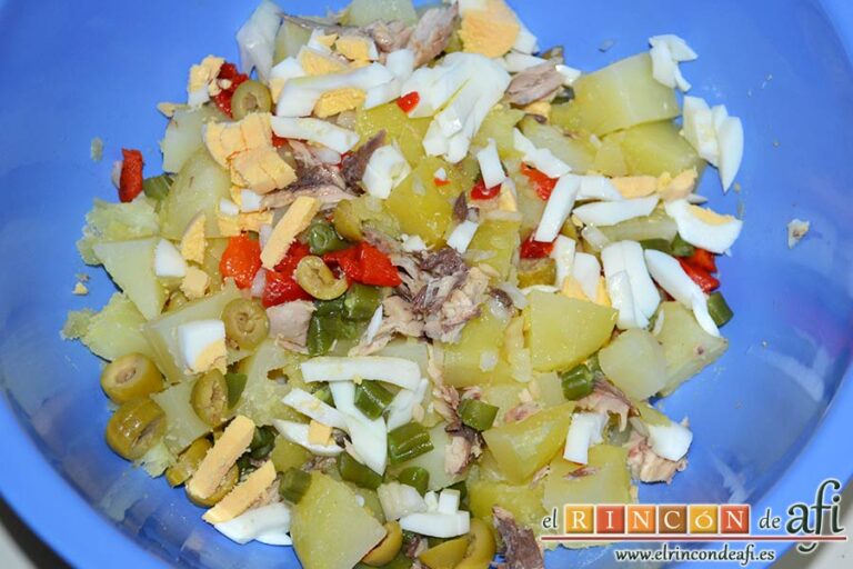 Ensaladilla de papas, verduras y filetes de caballa en aceite de oliva, remover