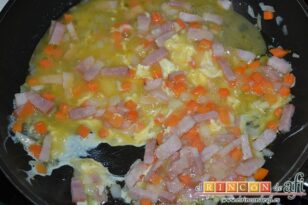 Arroz frito con verduras, bacon y huevos, batir los huevos y añadir a la sartén