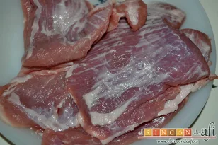 Secreto de cerdo al horno con papas panaderas y pimiento rojo, retirar exceso de grasa y cortar en trozos medianos