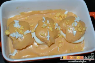Huevos rellenos gratinados con salsa aurora, decorar con la yema y clara picadas