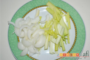 Papillote de lubina de ración con verduras, picar el puerro y la cebolla